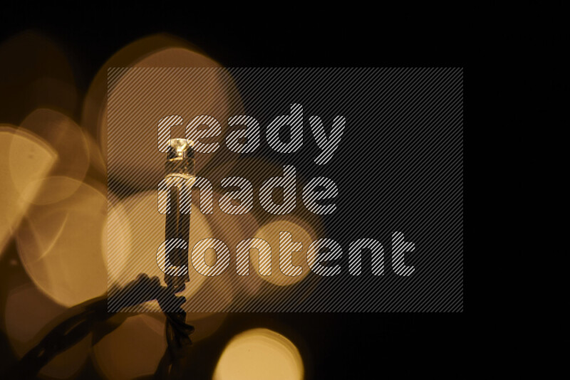 Light bulbs glowing against backdrop of golden bokeh