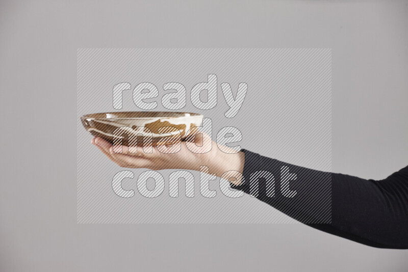 A woman in black abaya holding different pottery essentials in different positions
