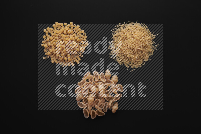 Different pasta types in bunches on black background