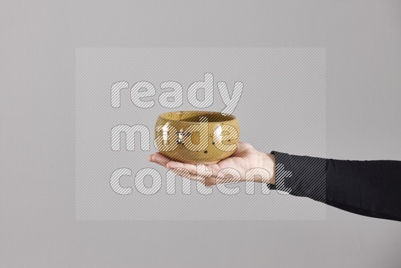 A woman in black abaya holding different pottery essentials in different positions
