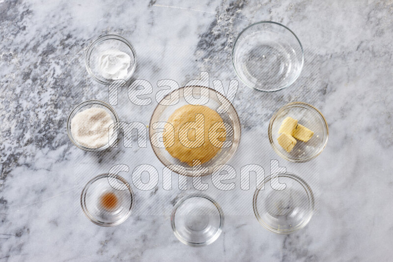 Cookies step by step with its ingredient, flour, butter, brown sugar, egg, vanilla extract, white sugar, chocolate chips and baking soda on grey marble background