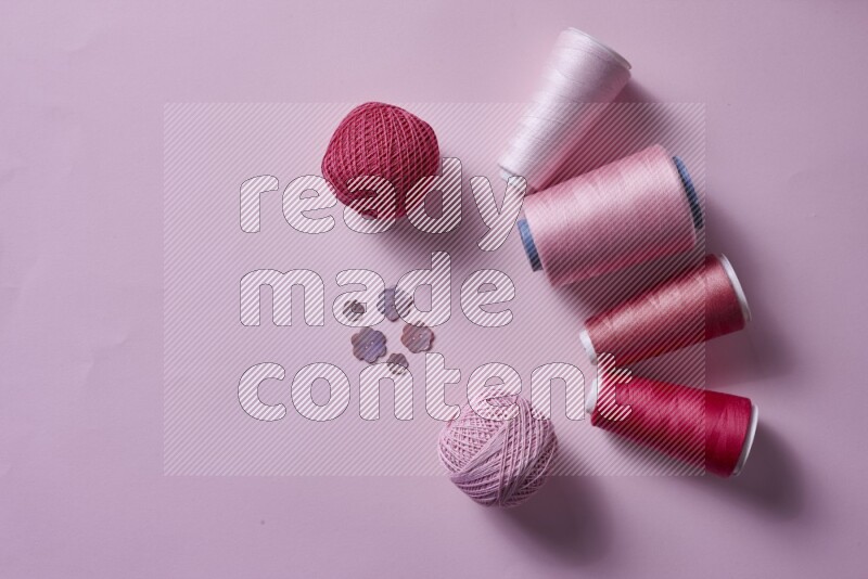 مجموعة من أدوات الخياطة والتفصيل زهرية اللون على خلفية زهرية