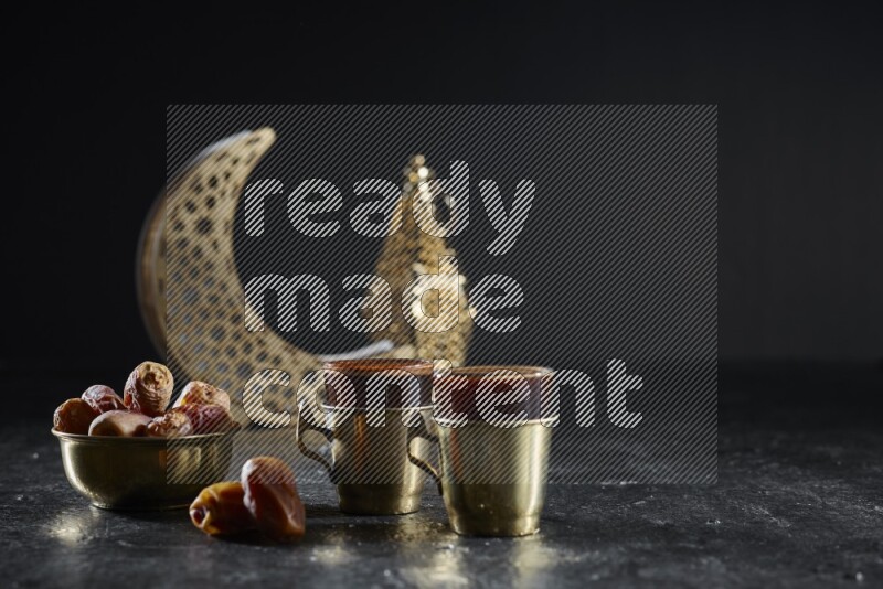 تمر مع مشروبات ساخنة وفوانيس ذهبية علي خلفية سوداء خشبية