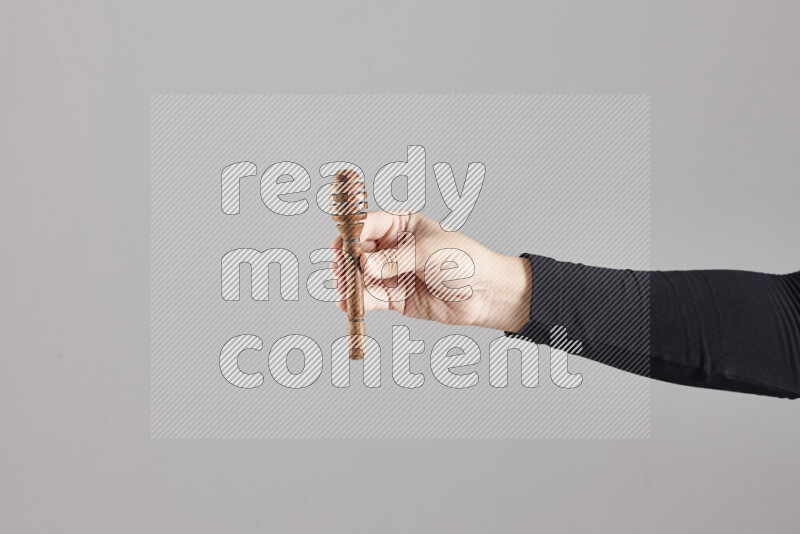 A woman in black abaya holding different wooden essentials in different positions