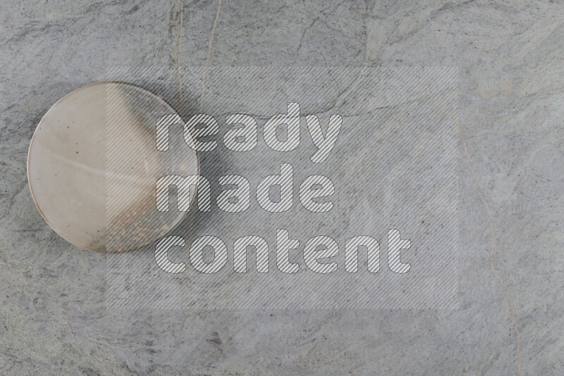 صحن فخاري متعدد الألوان على خلفية من الرخام الرمادي