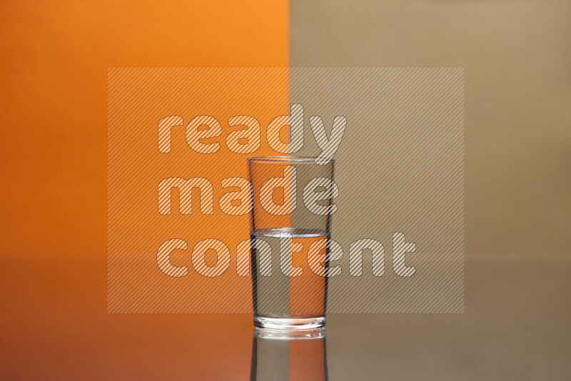 The image features a clear glassware filled with water, set against orange and beige background