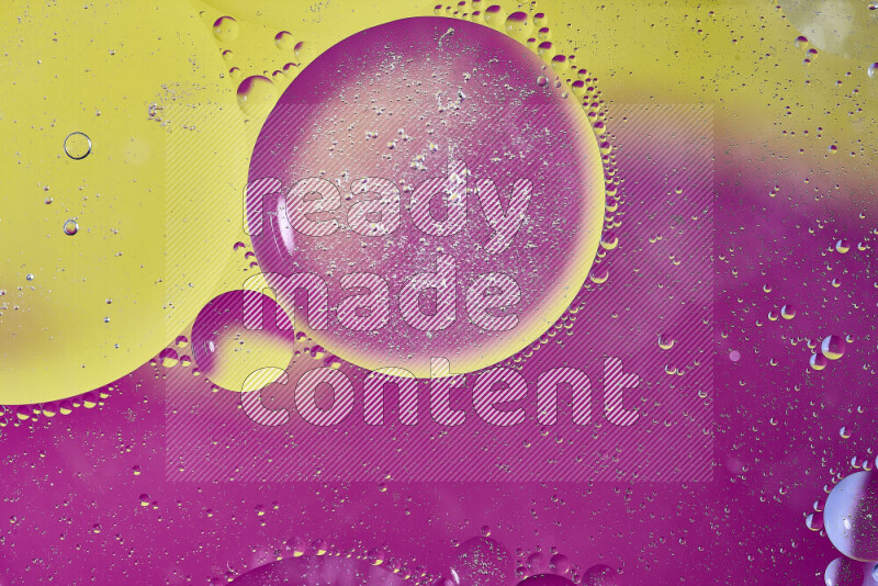 Close-ups of abstract oil bubbles on water surface in shades of yellow and pink