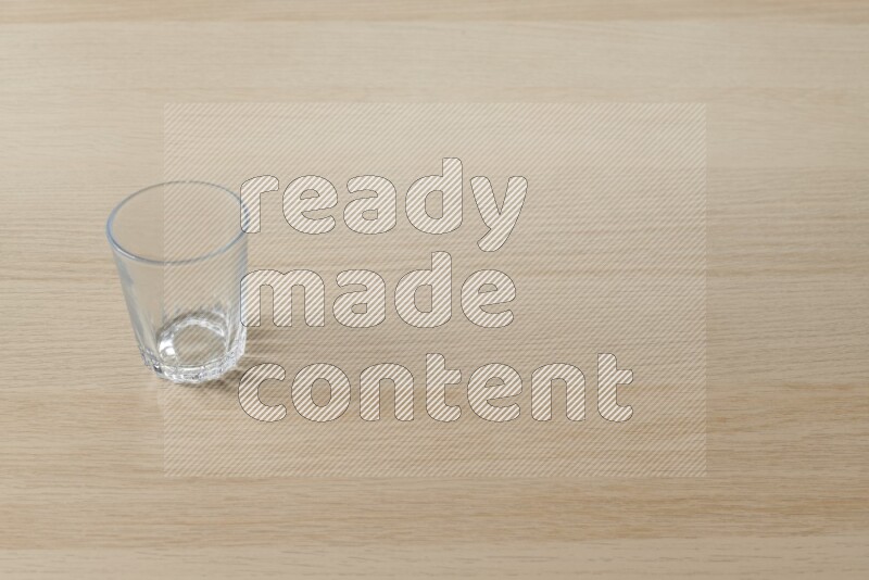 An empty glass cup on light wooden background