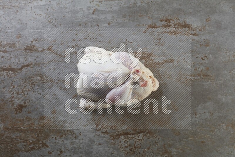 whole raw chicken  direct on a rustic grey background