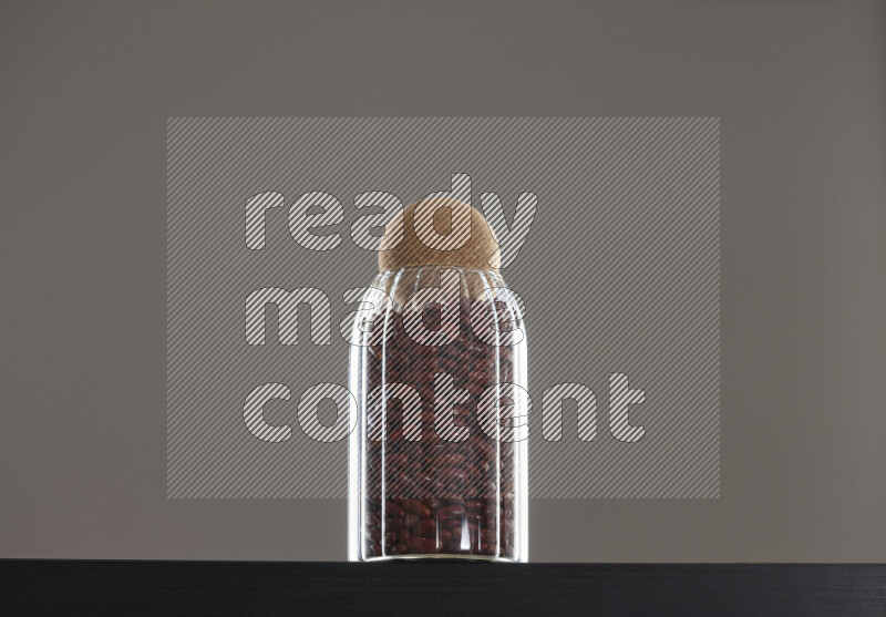 Red kidney beans in a glass jar on black background