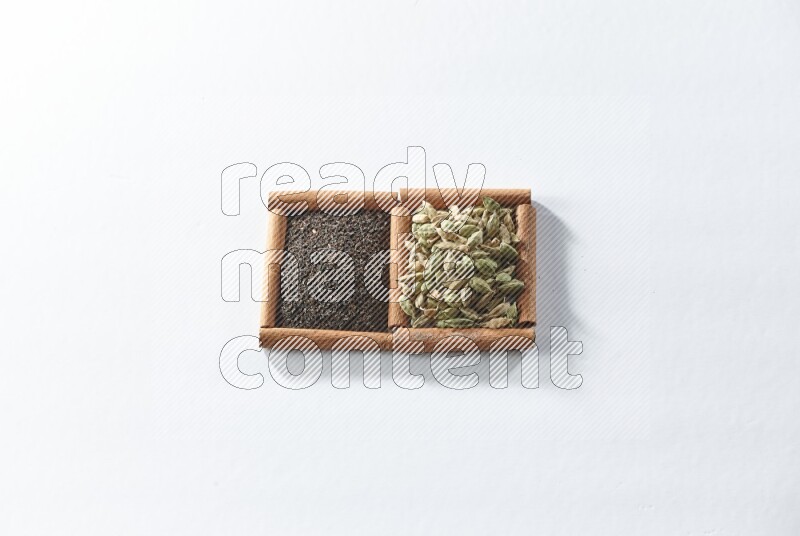2 squares of cinnamon sticks full of black tea and cardamom on white flooring