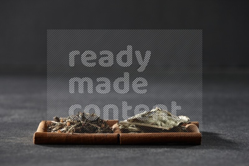2 squares of cinnamon sticks full of bay laurel leaves and dried basil on black flooring