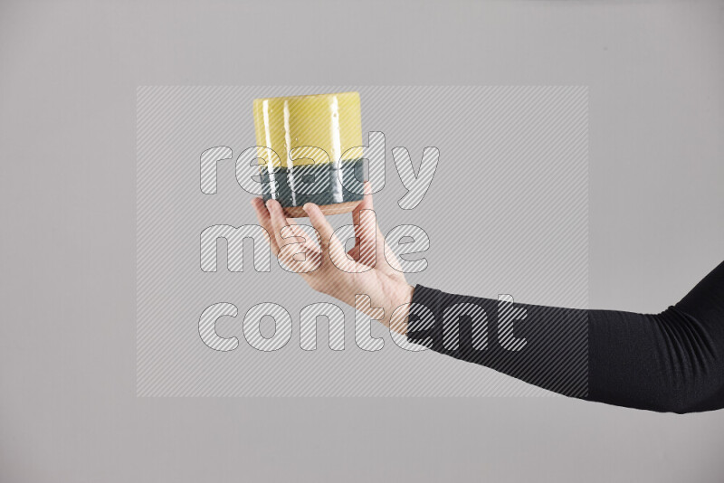 A woman in black abaya holding different pottery essentials in different positions
