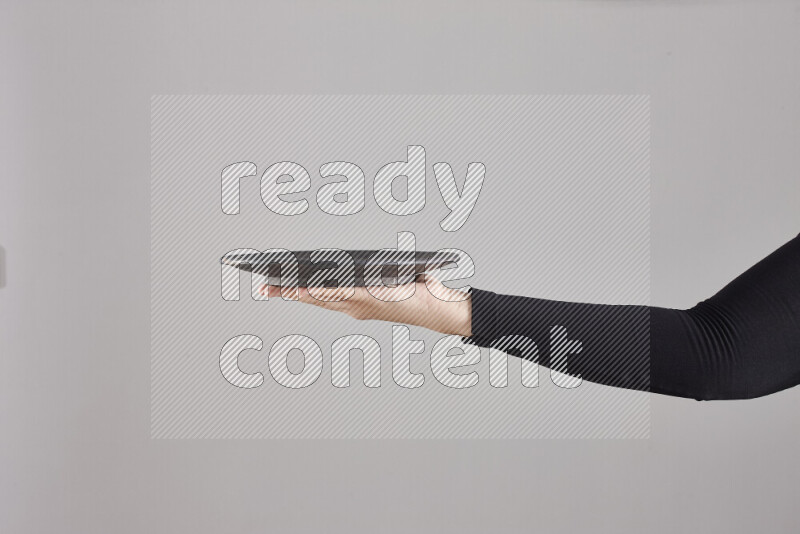 A woman in black abaya holding different pottery essentials in different positions