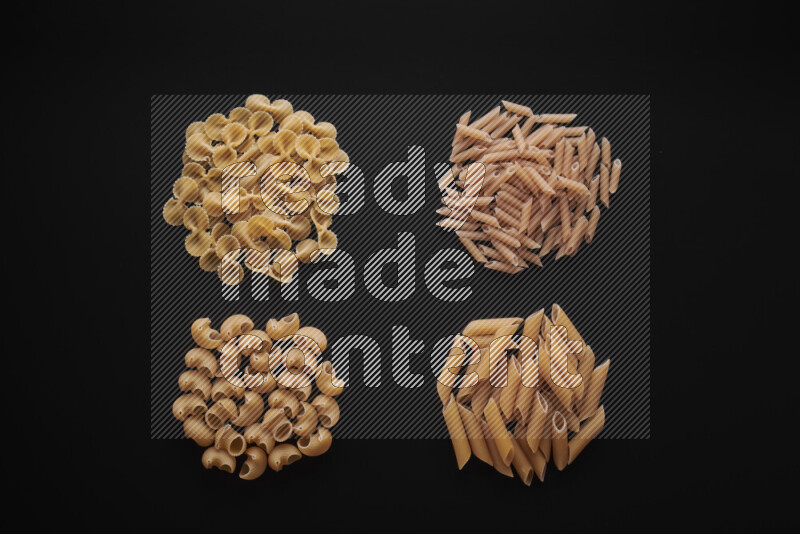 Different pasta types in bunches on black background