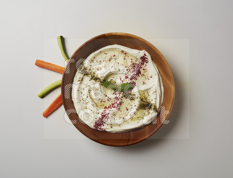 Lebnah garnished with  zattar , sumak & mint in a wooden plate on a white background