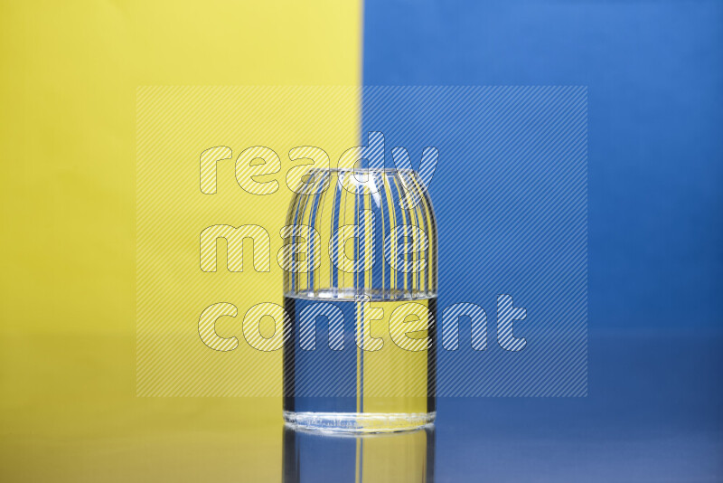 The image features a clear glassware filled with water, set against yellow and blue background