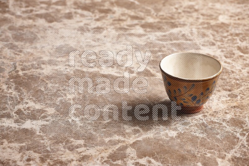 A decorative pottery bowl on beige marble background