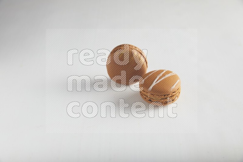 45º Shot of of two assorted Brown Irish Cream, and Brown Coffee macarons  on white background