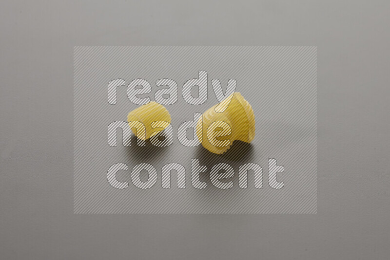 Big rings pasta with other types of pasta on grey background