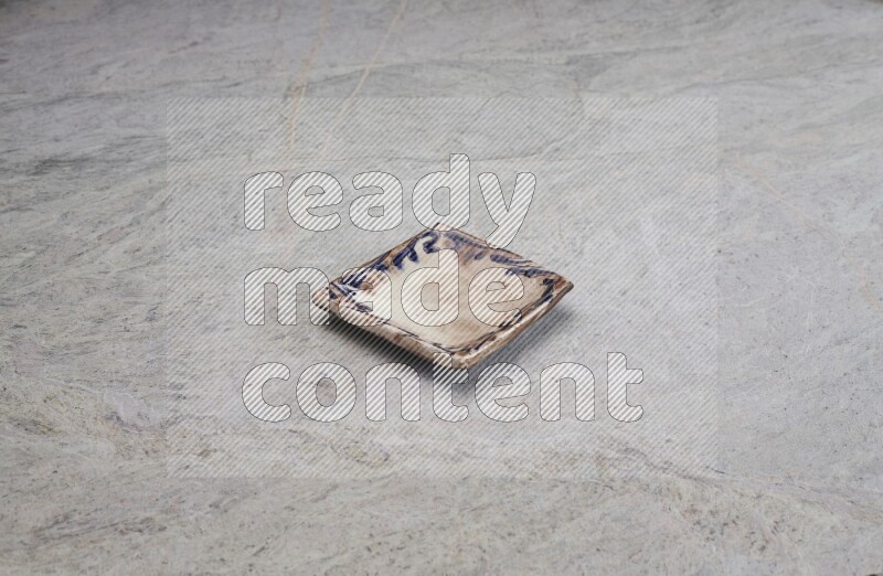 A decorative pottery plate on grey marble background