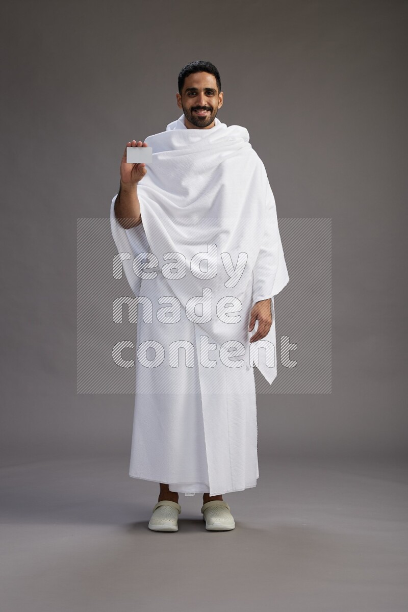 A man wearing Ehram Standing holding ATM card on gray background