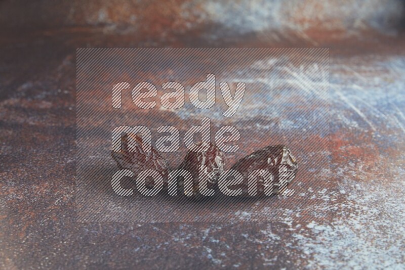 three madjoul dates on a rustic reddish background