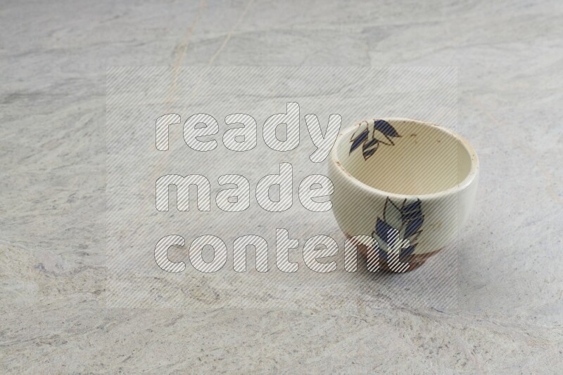 A multicolored pottery bowl on grey marble background