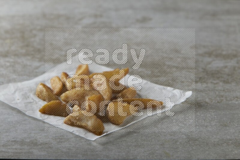 wedges potato on parchment paper on grey textured counter top