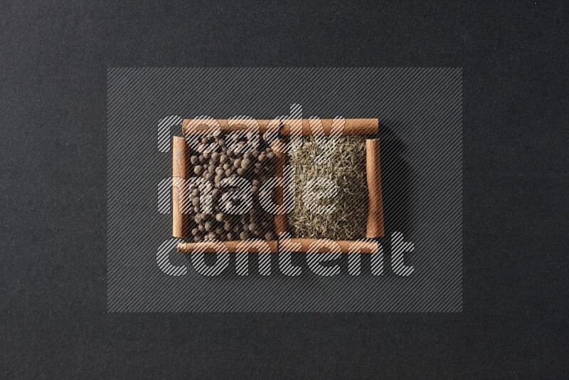 2 squares of cinnamon sticks full of cumin and allspice on black flooring