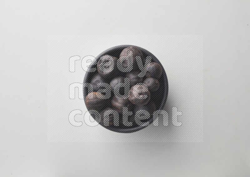 Top-view shot of dried lime (loomi) in a container on white background