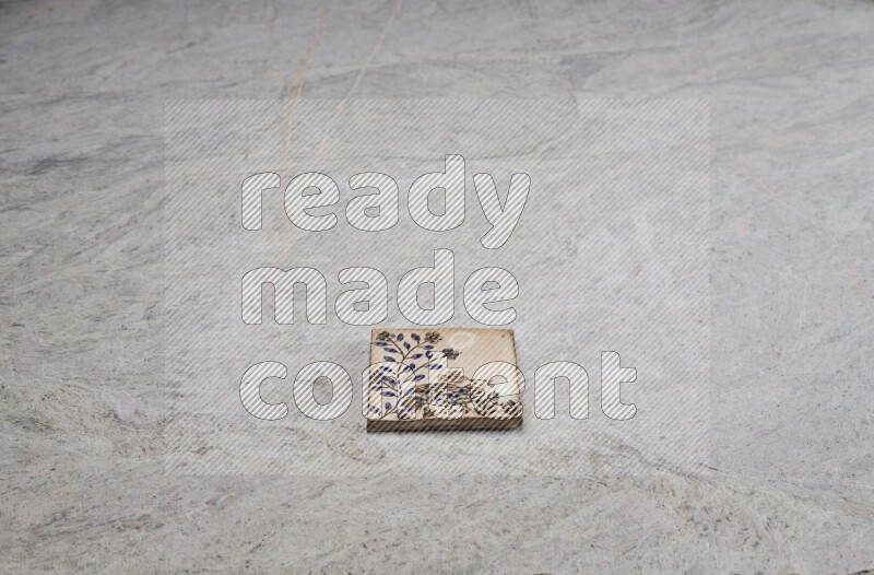 Top view shot of a pottery coaster\ tile on beige marble flooring