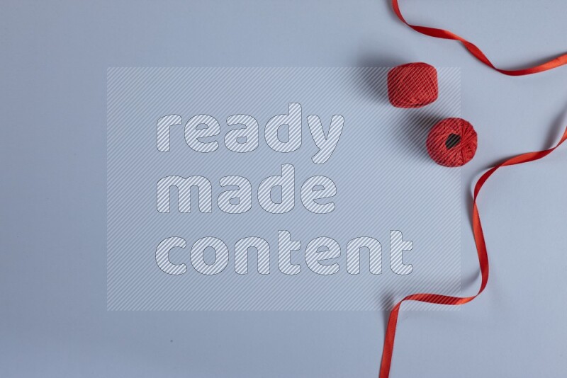 A red collection of sewing and tailoring tools arranged on a blue background