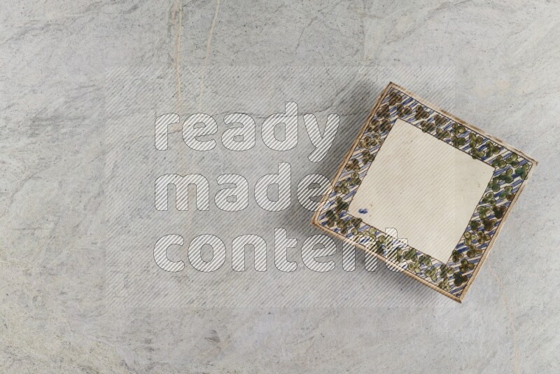 A decorative pottery plate on grey marble background