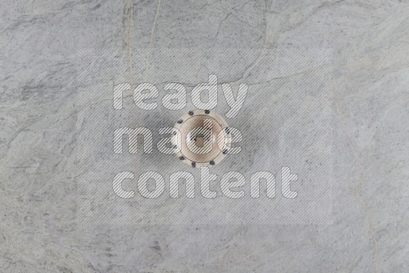 A decorative pottery plate on grey marble background