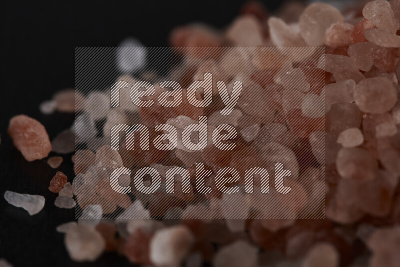 A bunch of coarse himalayan salt crystals on black background
