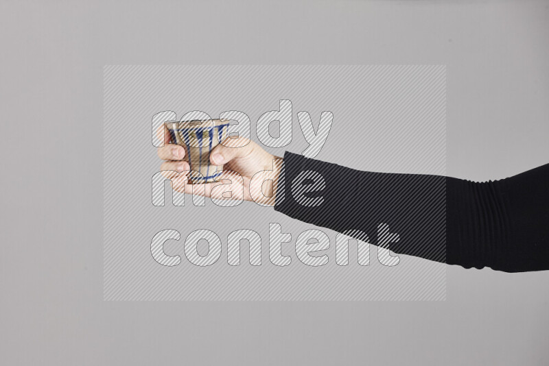 A woman in black abaya holding different pottery essentials in different positions