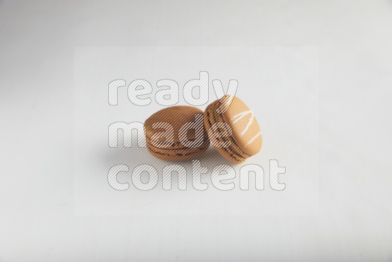45º Shot of of two assorted Brown Irish Cream, and Brown Coffee macarons  on white background