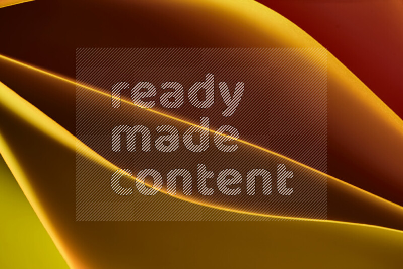 هذه الصورة تعرض تكوين فن الورق التجريدي مع منحنيات ورقية بتدرجات اللون الأصفر والأحمر والبني المكونه بواسطة الضوء الملون