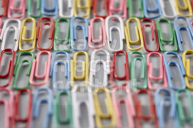 Multicolored paper clips isolated on a grey background