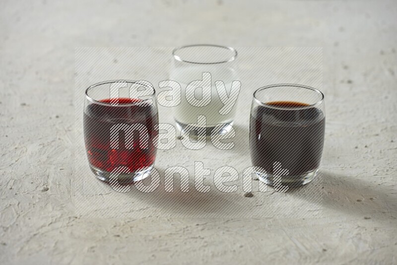 Cold drinks in a glass cup such as water, tamarind, qamar eldin, sobia, milk and hibiscus on textured white background