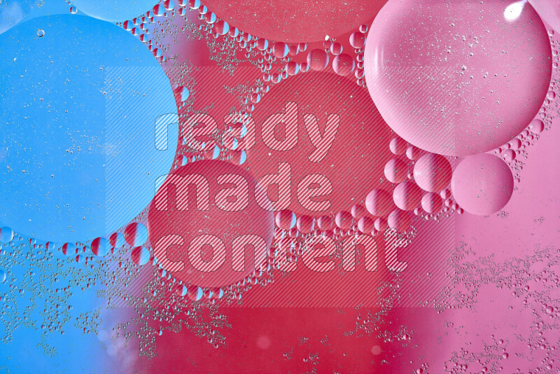 Close-ups of abstract oil bubbles on water surface in shades of blue, red and pink