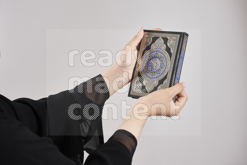 امرأة تحمل بيديها مصحف القرآن في أوضاع متعددة