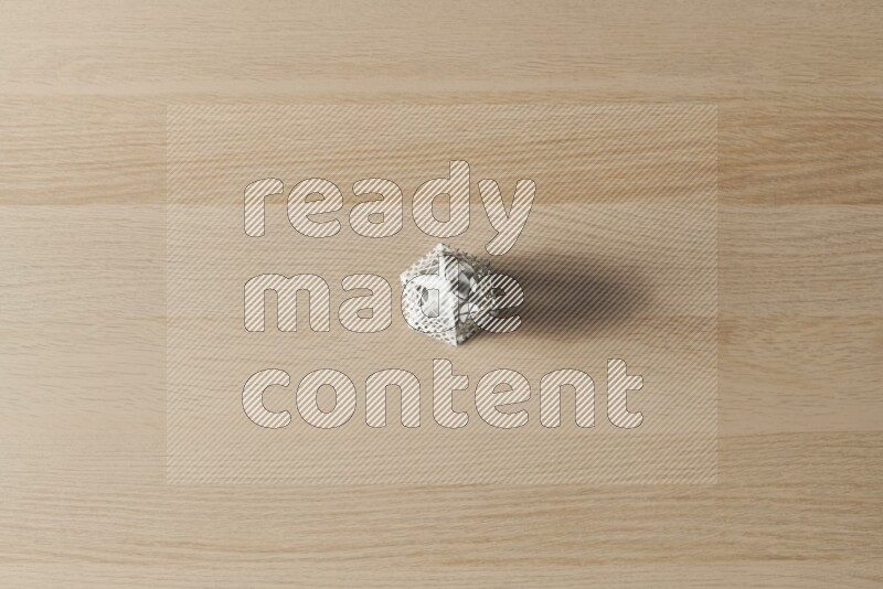 A candle lantern on light wooden background