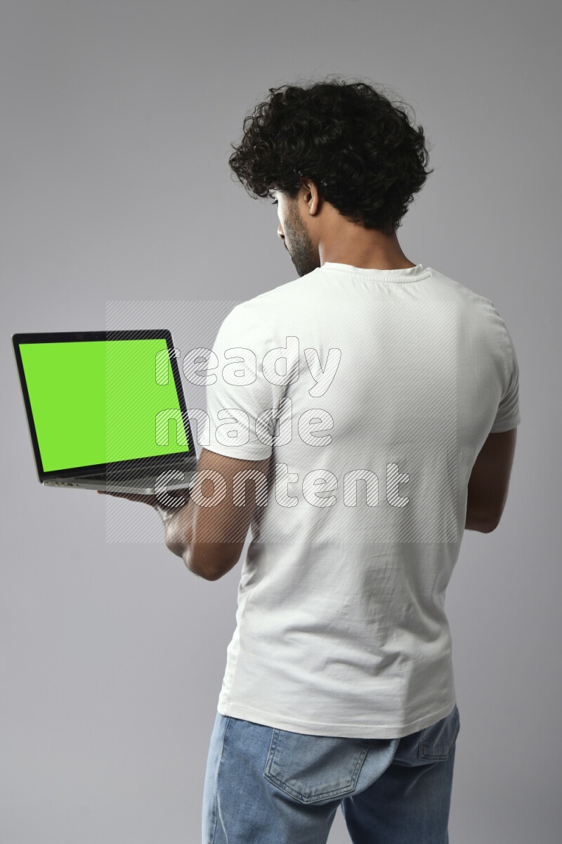 A man wearing casual standing and showing a laptop screen on white background