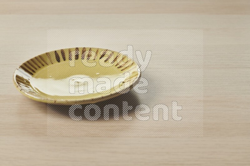 A multicolored pottery plate on light wooden background