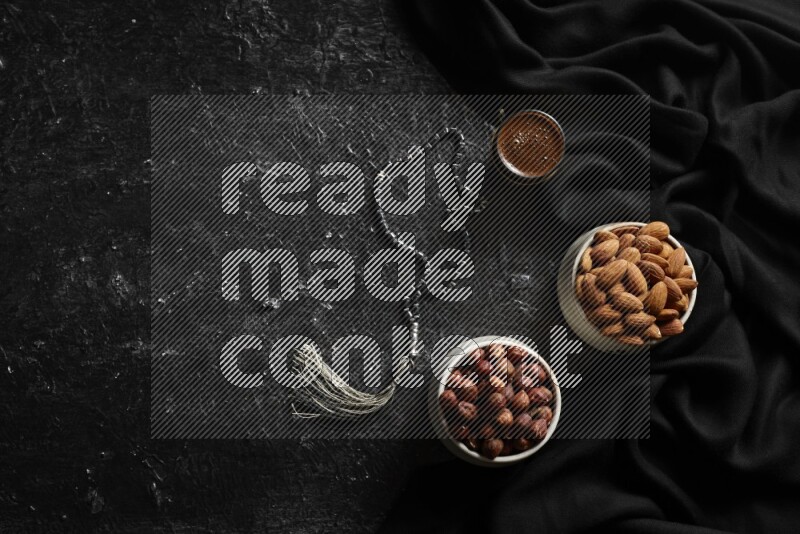 Nuts in pottery bowls with coffee in a dark setup