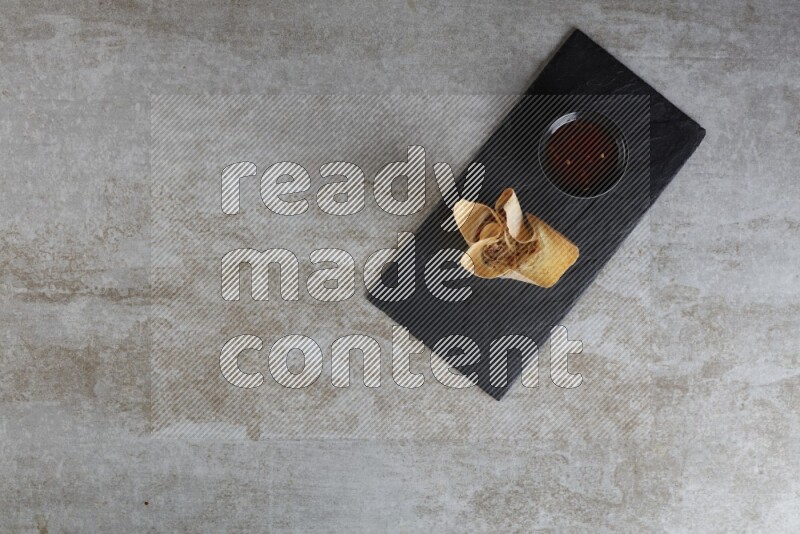 wonton cups with soy sauce ramkin on rectangle slate on grey textured counter top