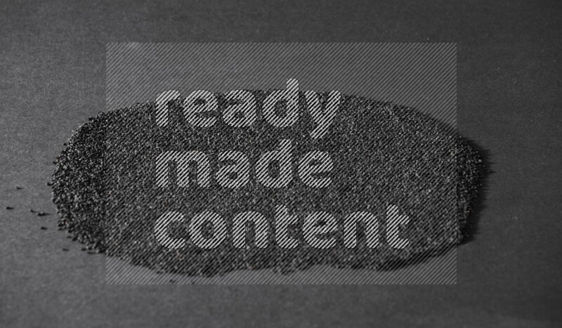 Black seeds filling the frame on a black flooring