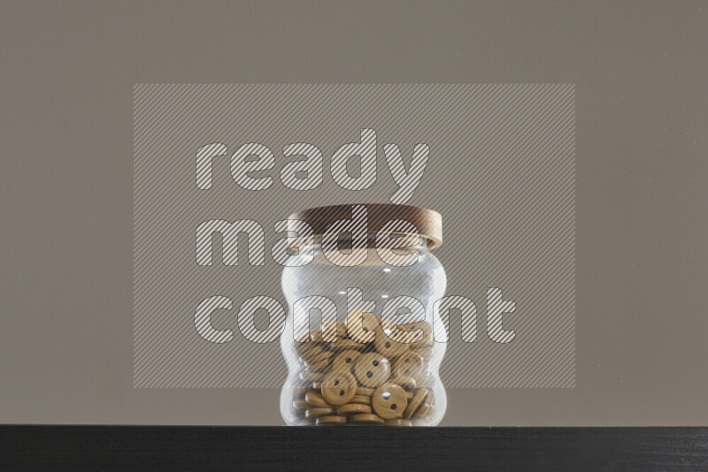 Buttons in a glass jar on black background
